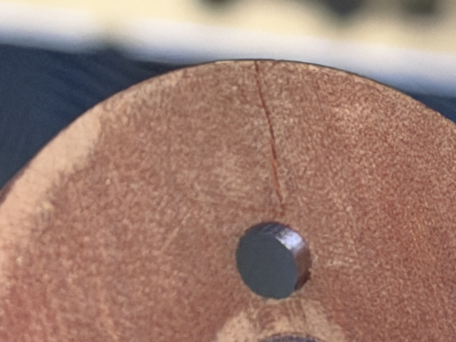 Removed pitch servo pulley: wood-grain texture, crack running from the shear-screw bore to the rim